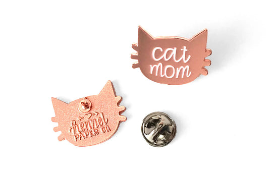 Rose gold cat-shaped pins with 'cat mom' text on a white background